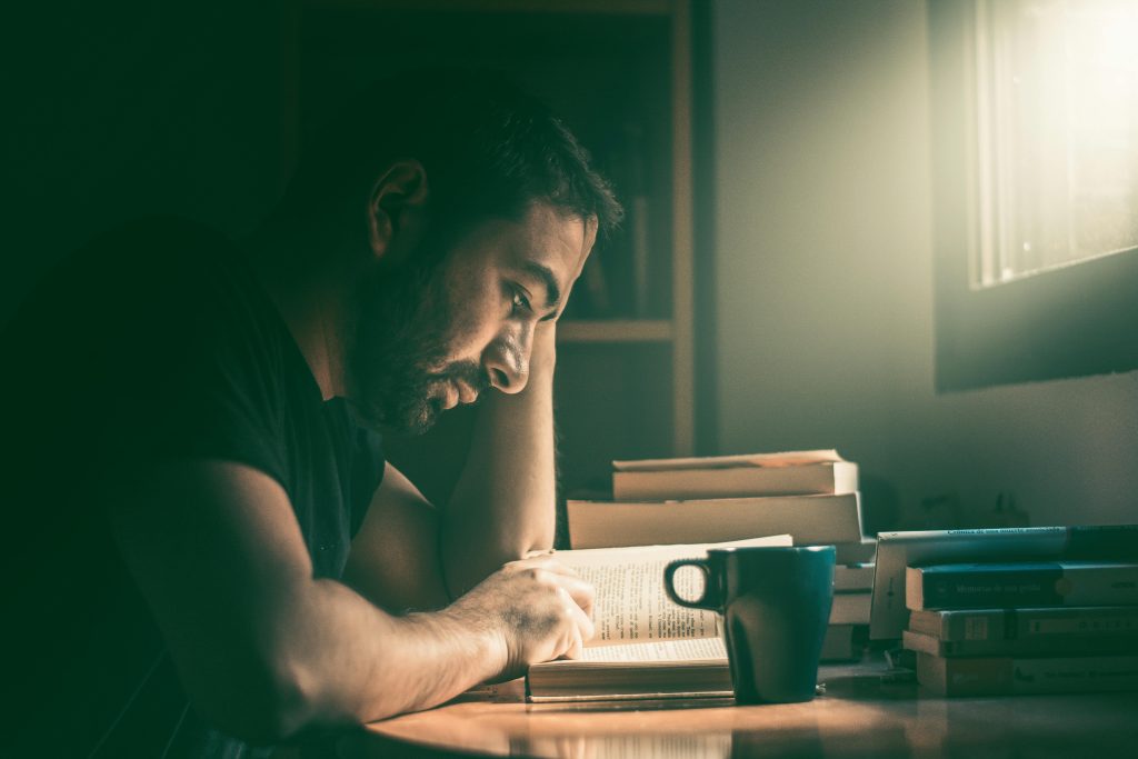 pexels-photo-3563697-3563697 An adult man immersed in reading by the window in Madrid. Warm, focused study atmosphere.