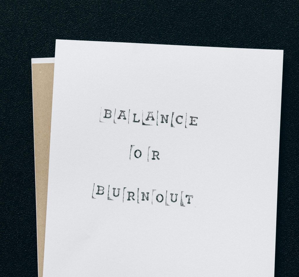 A simple card displaying the message 'Balance or Burnout' emphasizing mental health and stress management.