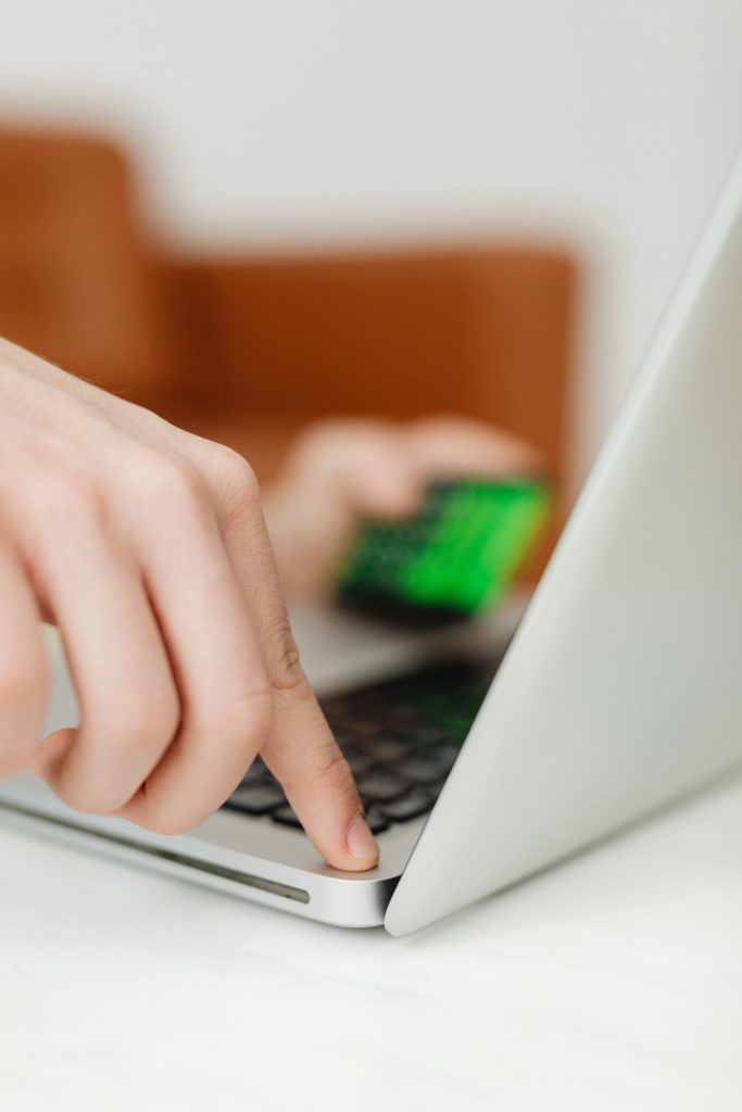 pexels-photo-6958485-6958485 Close-up of a finger pressing the power button on a laptop, indicating technology interaction.